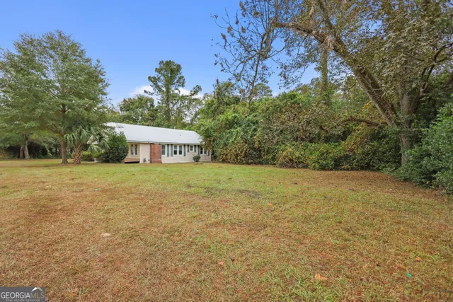a view of a house with yard and tree s