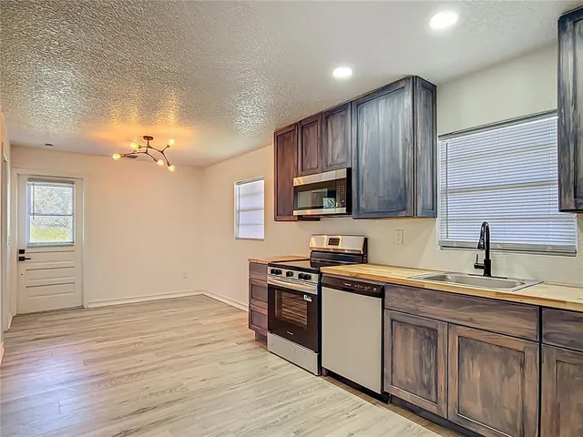a kitchen with a sink cabinets and wooden floor