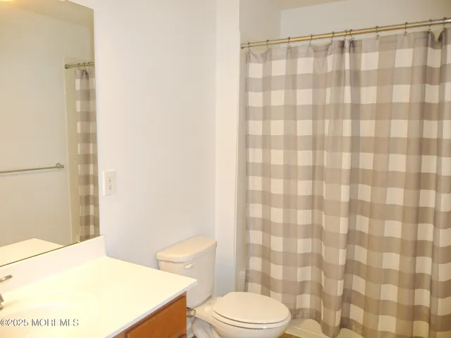 a white toilet sitting next to a shower curtain