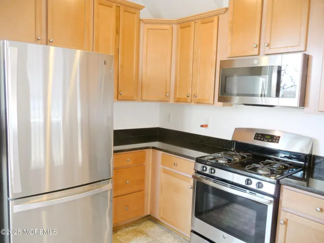a kitchen with stainless steel appliances a stove a microwave and a refrigerator