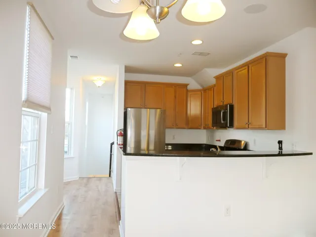 a view of a kitchen with a sink and a refrigerator