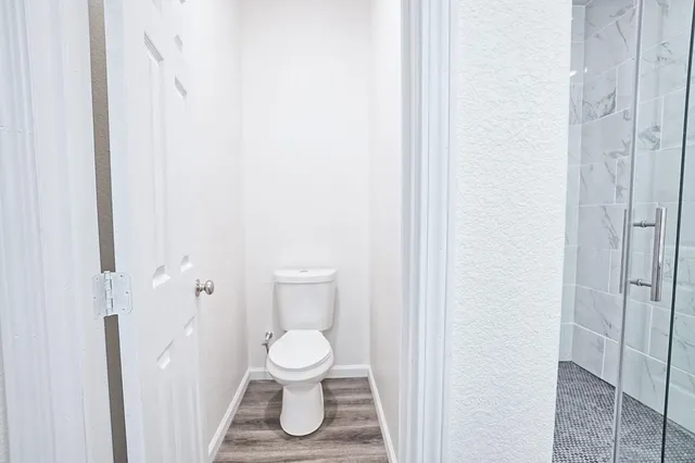 a white toilet sitting next to a white tub