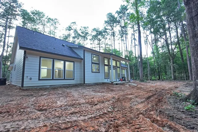 a view of a house with a yard and large tree