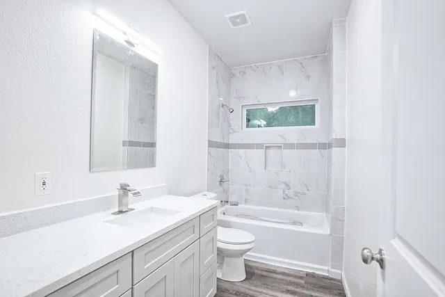 a bathroom with a sink a toilet and shower