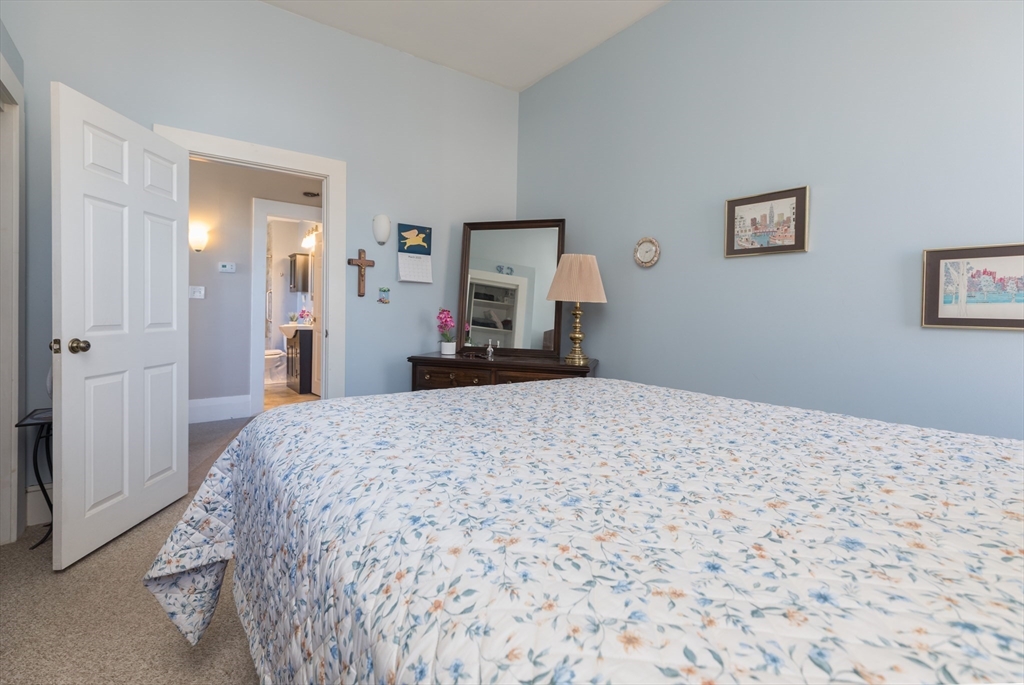 215 Central Street Saugus, MA 01906 - Photo 19 of 41 a bedroom with a bed and a chandelier