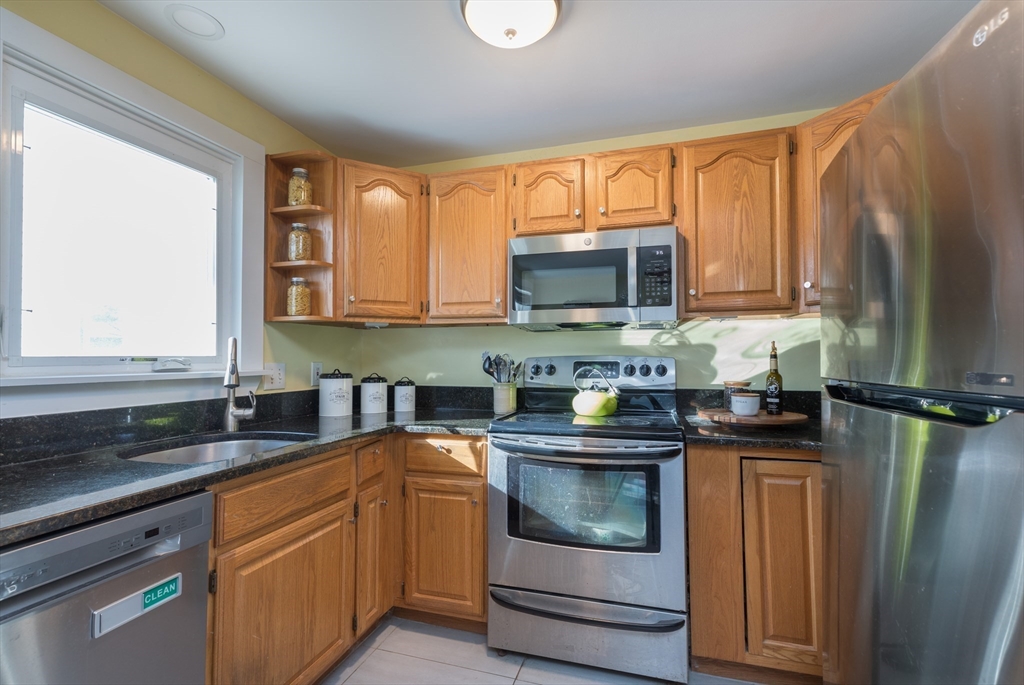215 Central Street Saugus, MA 01906 - Photo 10 of 41 a kitchen with stainless steel appliances granite countertop a stove a sink and a microwave