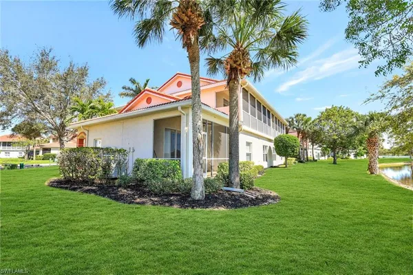 a front view of a house with a yard and trees