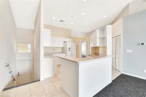 a kitchen with white cabinets and sink