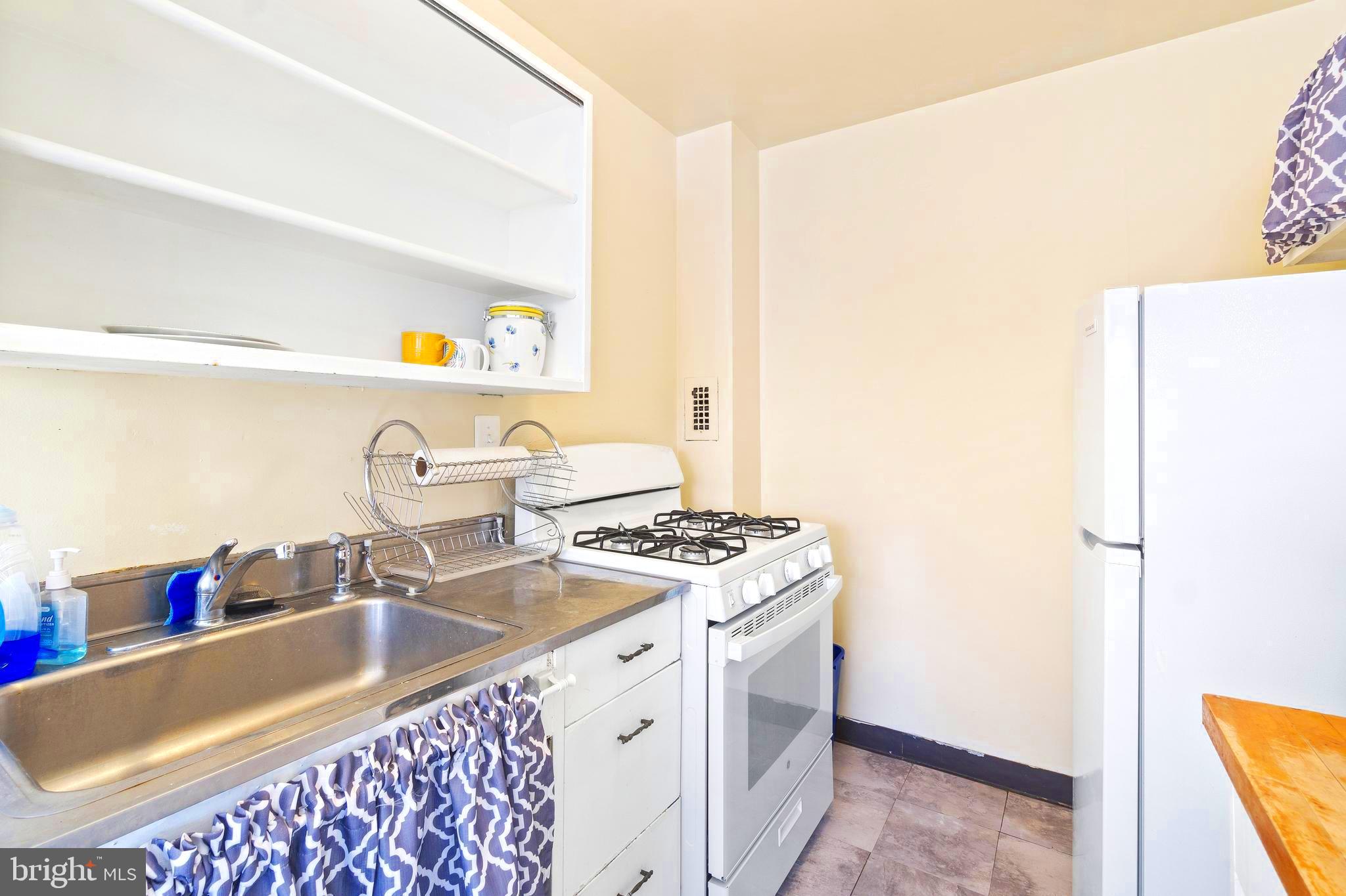 8601 Manchester Road, Unit 513 Silver Spring, MD 20901 - Photo 11 of 31 a kitchen with a sink stove and a refrigerator