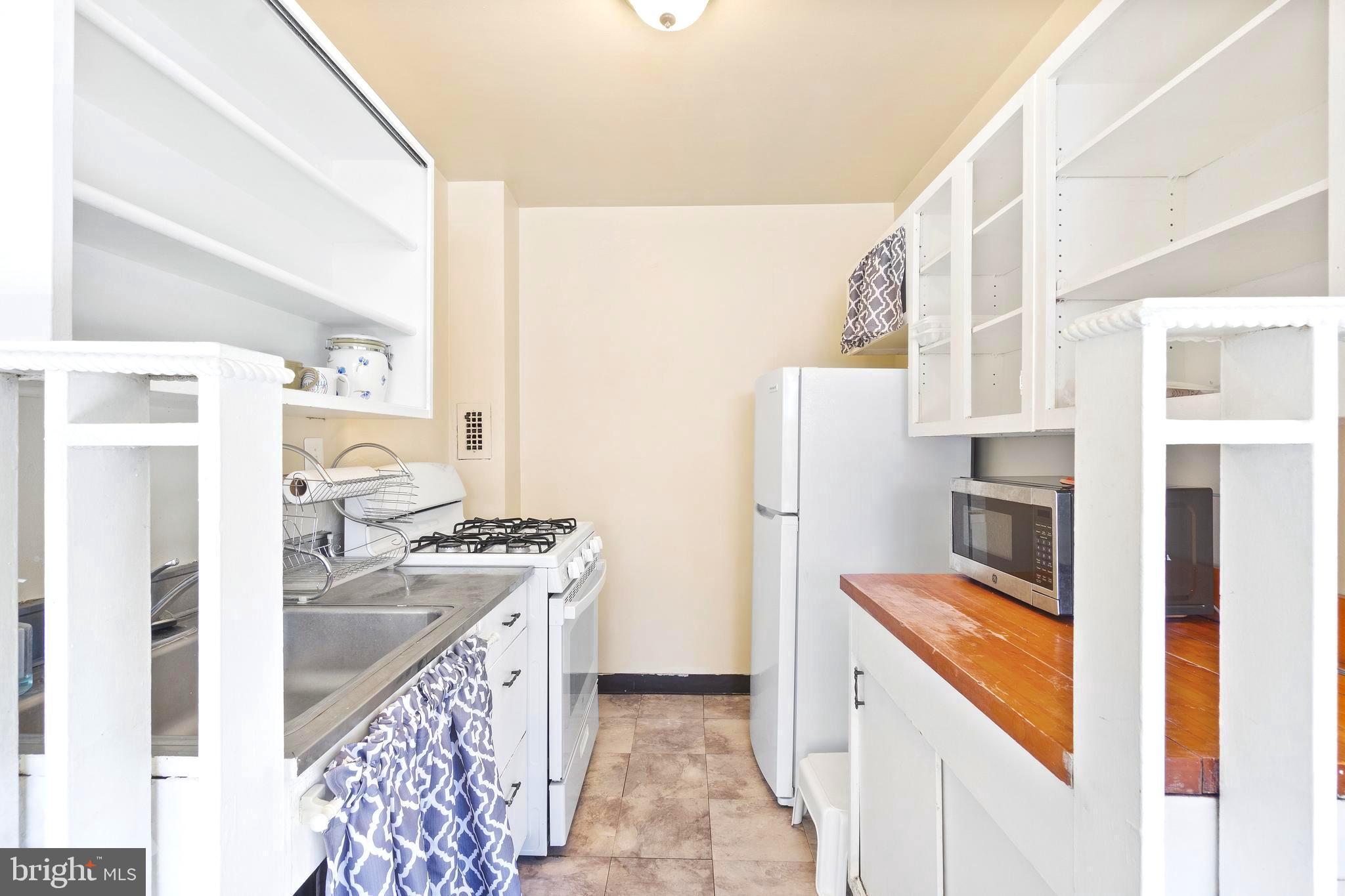 8601 Manchester Road, Unit 513 Silver Spring, MD 20901 - Photo 10 of 31 a kitchen with stainless steel appliances granite countertop a refrigerator a stove and a sink with wooden floor