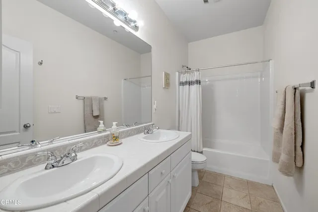 a bathroom with a double vanity sink toilet and shower