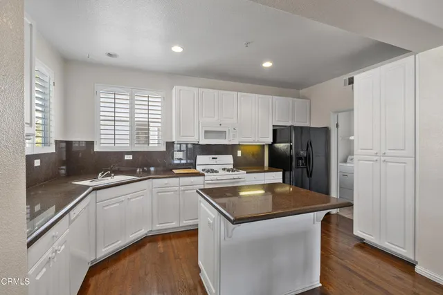 a kitchen with granite countertop a sink stove and cabinets