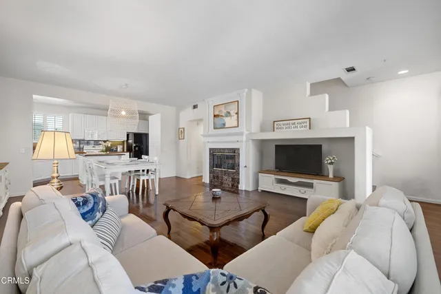 a living room with furniture a fireplace and a flat screen tv