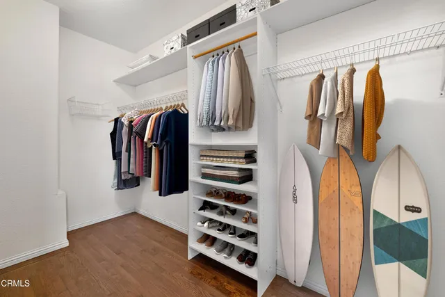 a view of walk in closet with clothes and shoes