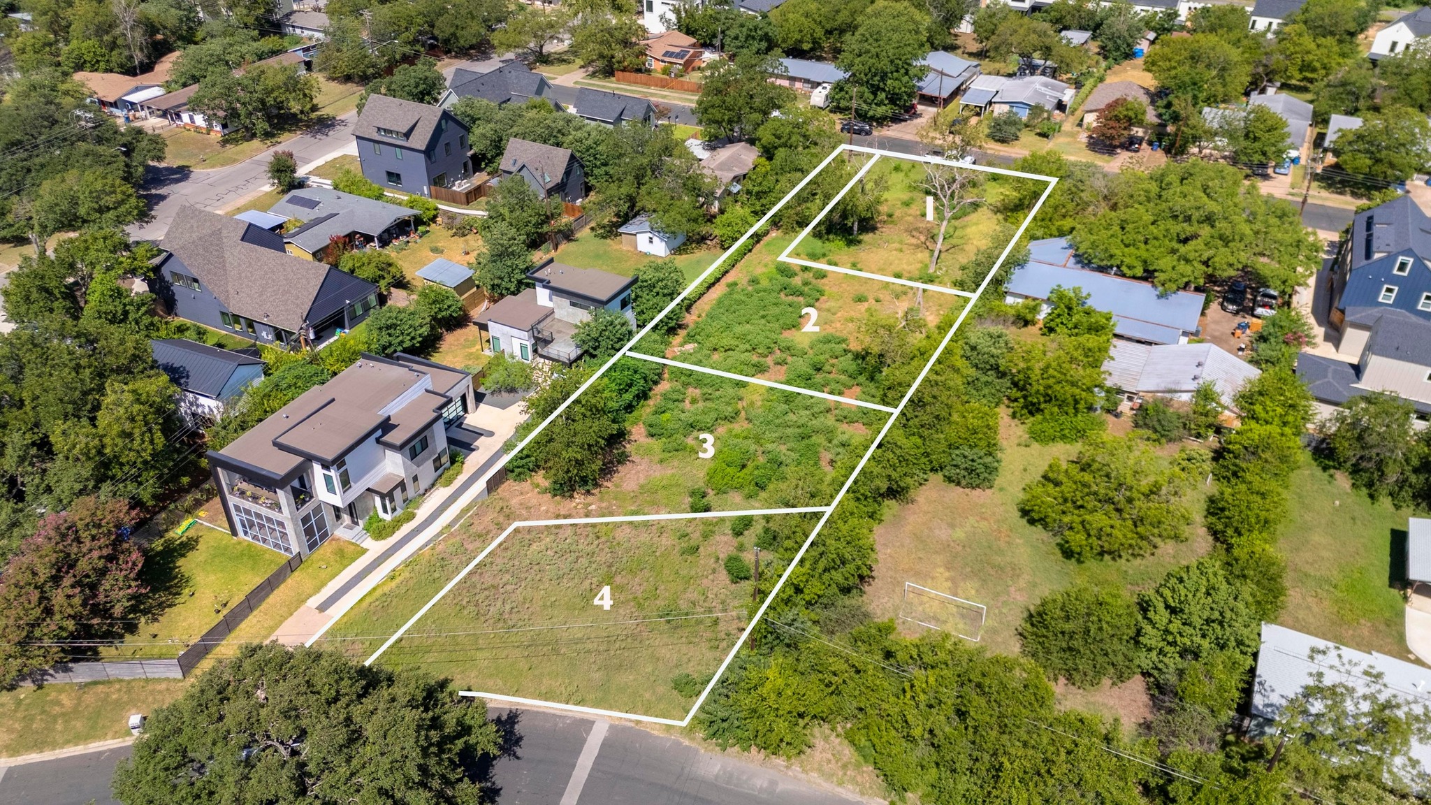 an aerial view of residential houses with outdoor space and street view