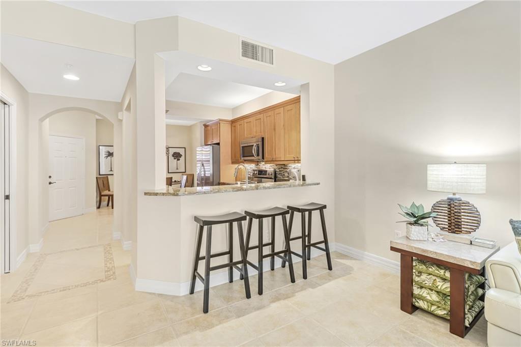 401 Bayfront Place, Unit 3205 Naples, FL 34102 - Photo 4 of 35 a kitchen with kitchen island granite countertop lots of white cabinets a sink and appliances