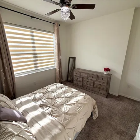 a bedroom with a bed dresser and a window