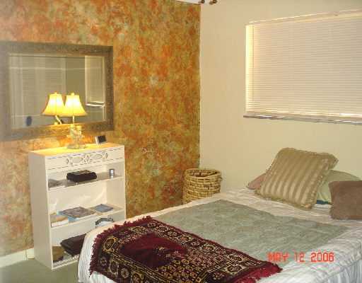 450 Southwest 2nd Avenue, Unit 208A Boca Raton, FL 33432 - Photo 7 of 10 a bedroom with a bed and a chandelier