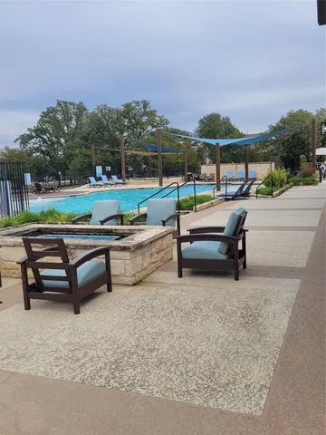 a view of a patio with a bench and trees