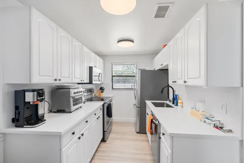 a kitchen with a sink a stove and cabinets