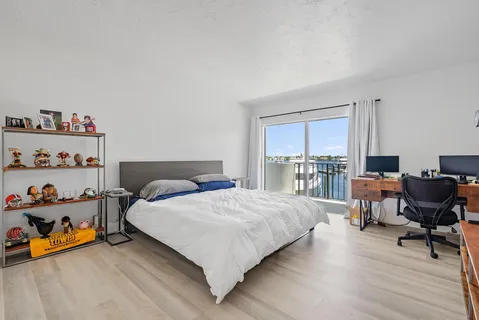 a bedroom with a bed a large window and chair