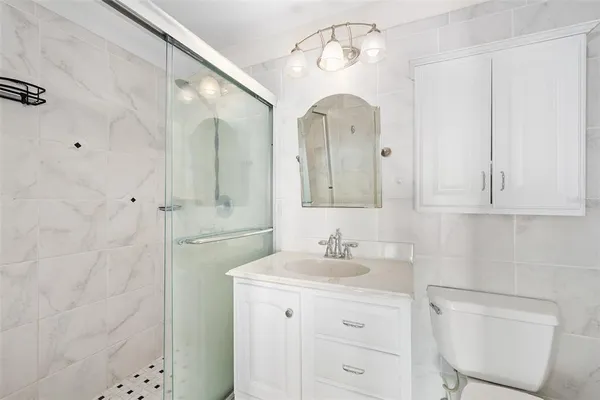 a bathroom with a sink a toilet and shower