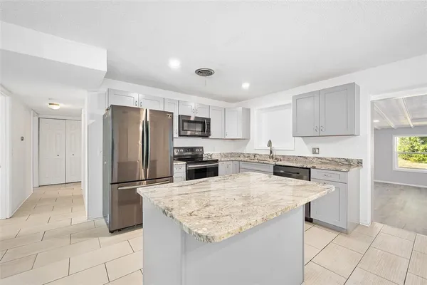 a kitchen with stainless steel appliances granite countertop a refrigerator and a stove top oven