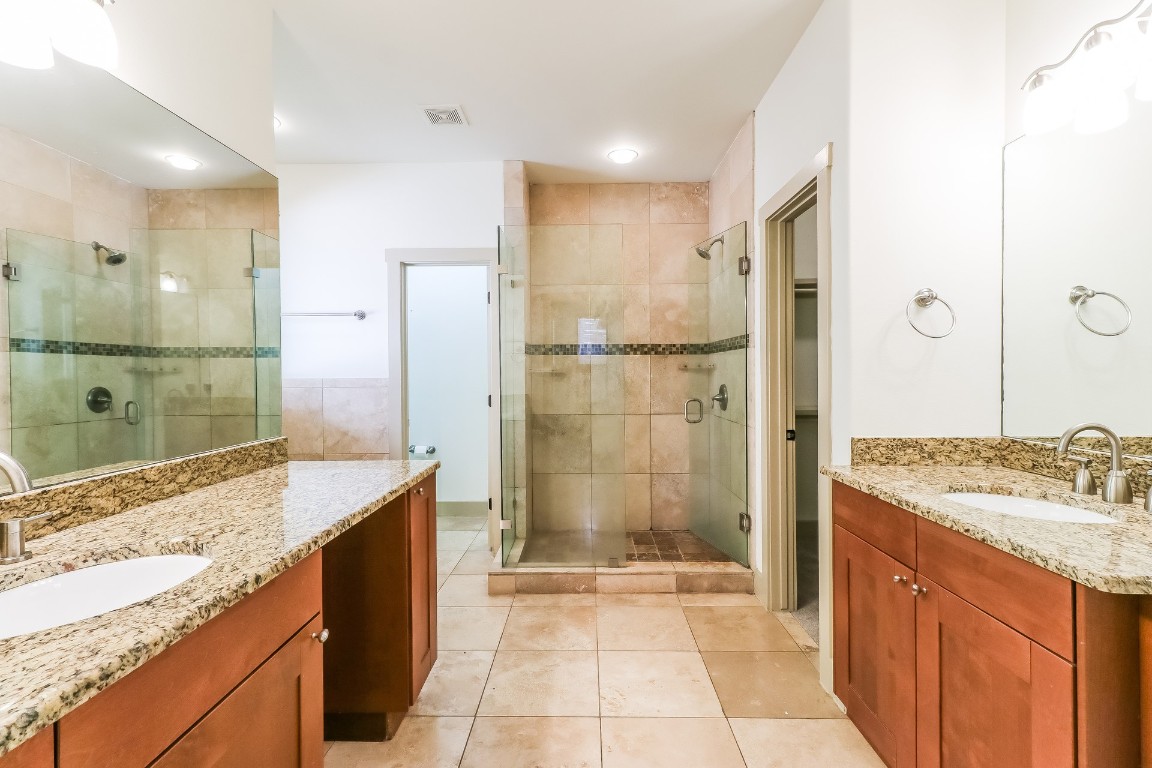 1212 Woodland Avenue, Unit A Austin, TX 78704 - Photo 11 of 20 a bathroom with a granite countertop sink mirror and shower