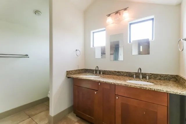 a bathroom with a granite countertop sink and a mirror