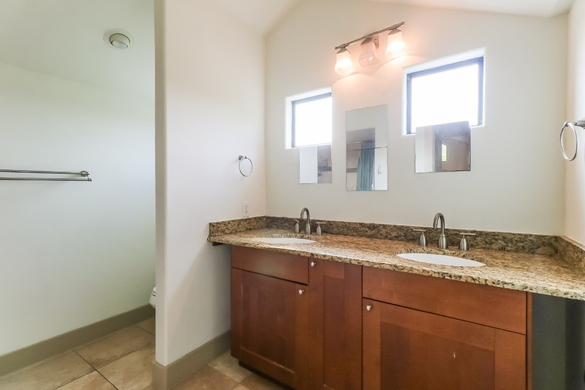 1212 Woodland Avenue, Unit A Austin, TX 78704 - Photo 12 of 20 a bathroom with a granite countertop sink and a mirror