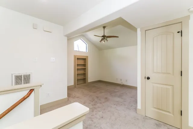 a view of an empty room with closet and a window