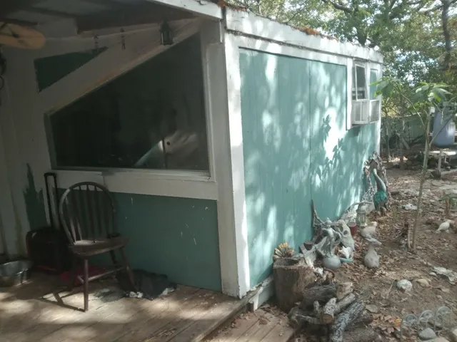 a backyard of a house with table and chairs and potted plants