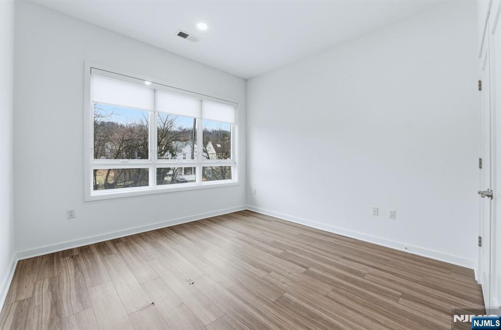 37 Orange Road, Unit 206 Montclair, NJ 07042 - Photo 8 of 16 a view of an empty room with wooden floor and a window