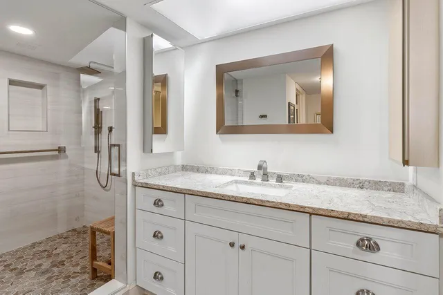 a bathroom with a granite countertop sink two mirror and a