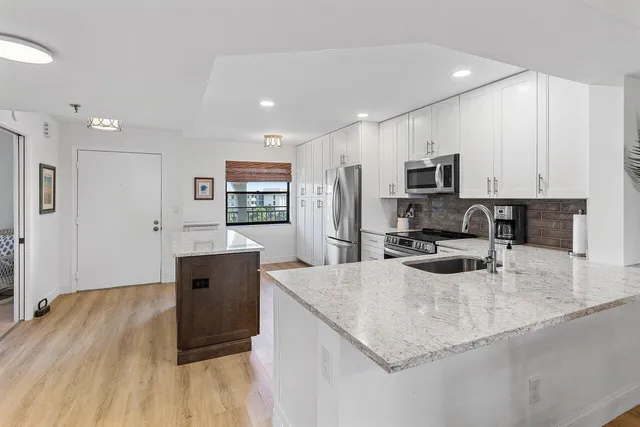a kitchen with stainless steel appliances granite countertop a sink stove microwave and refrigerator