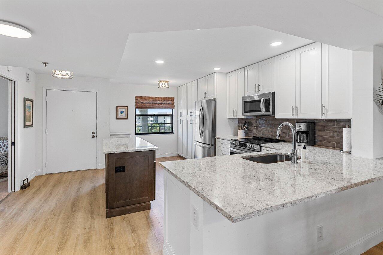 9220 Southwest 14th Street, Unit 3503 Boca Raton, FL 33428 - Photo 2 of 16 a kitchen with stainless steel appliances granite countertop a sink stove microwave and refrigerator