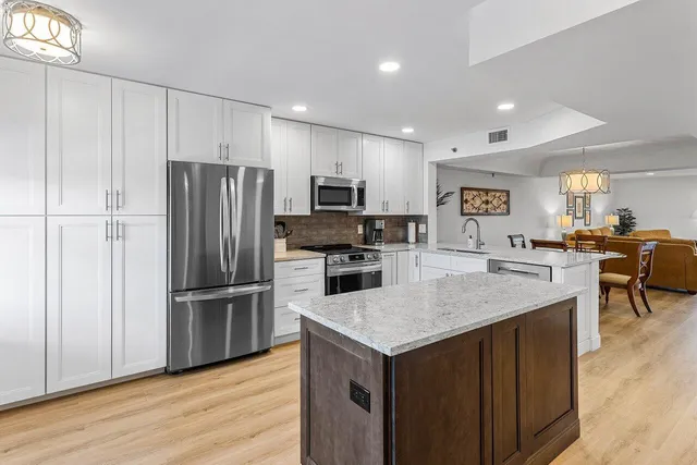 a kitchen with a refrigerator a microwave and wooden floor