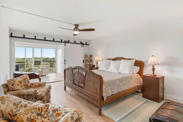 a spacious bedroom with a bed and wooden floor