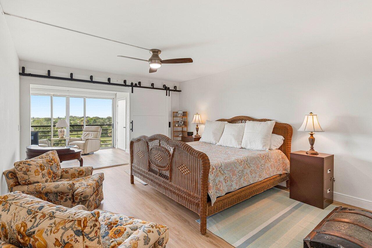 9220 Southwest 14th Street, Unit 3503 Boca Raton, FL 33428 - Photo 10 of 16 a spacious bedroom with a bed and wooden floor