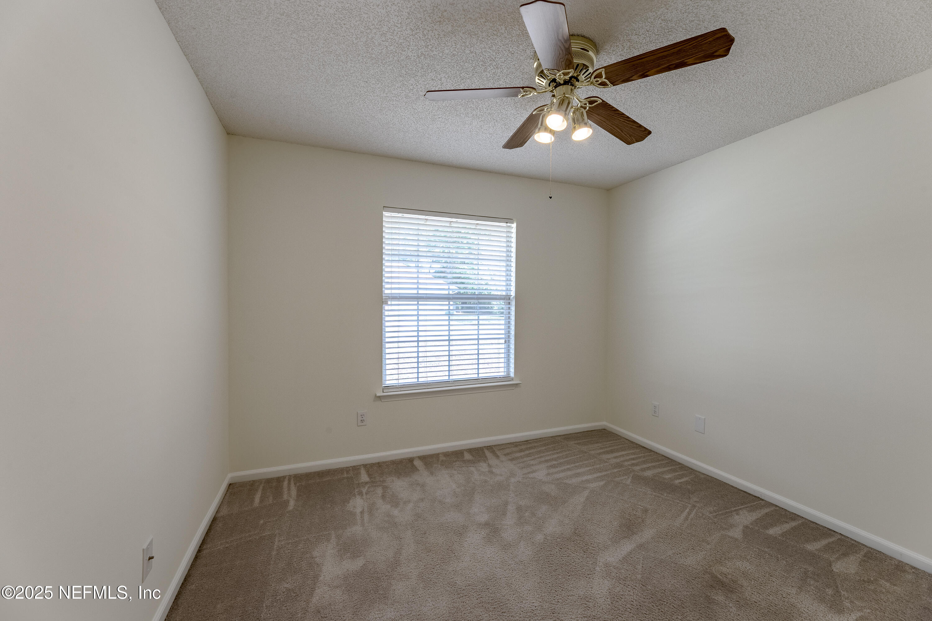 120 Clapton Way Jacksonville, FL 32220 - Photo 20 of 33 an empty room with a chandelier fan and windows