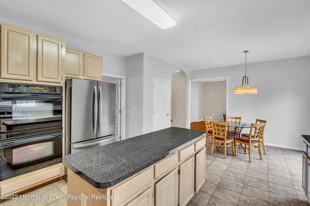 a kitchen with stainless steel appliances granite countertop a stove top oven a sink a refrigerator and cabinets