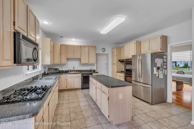 a kitchen with granite countertop stainless steel appliances a stove sink and cabinets