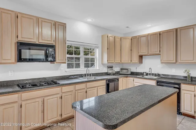 a kitchen with granite countertop a sink and cabinets