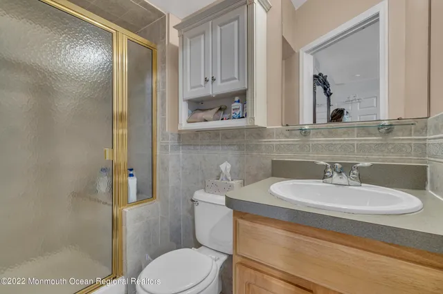a bathroom with a granite countertop sink a toilet and a mirror