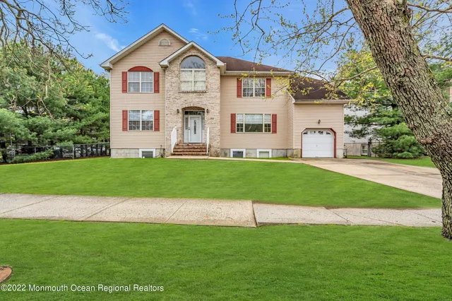 a view of a house with a yard and large trees