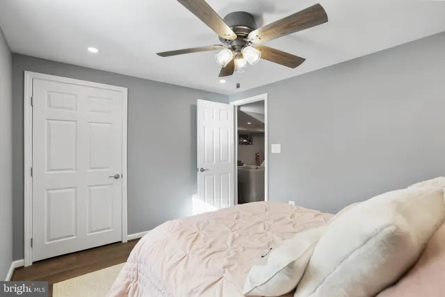 a living room with stainless steel appliances furniture a flat screen tv and a kitchen view