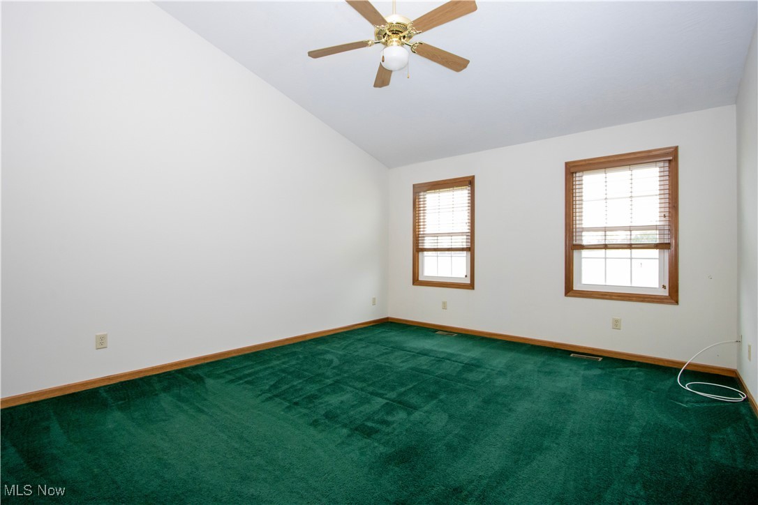 1500 Bell Road Wooster, OH 44691 - Photo 27 of 33 Spare room featuring baseboards, carpet, vaulted ceiling, and ceiling fan