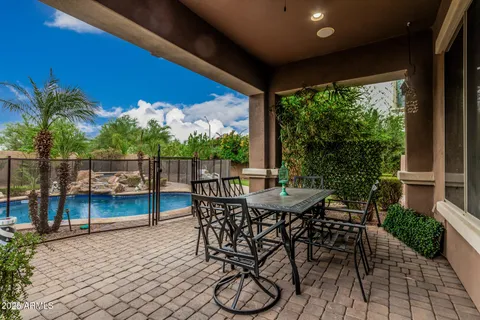 a view of a patio with table and chairs with wooden floor and fence