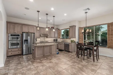 a kitchen with kitchen island a counter top space appliances and a dining table