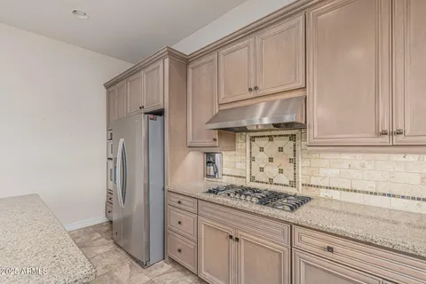 a kitchen with granite countertop a stove and a refrigerator
